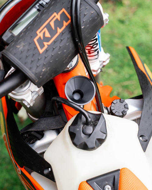 Close-up of a KTM motorcycle 2-stroke oil filler with a DIRT-EH 2-stroke oil funnel