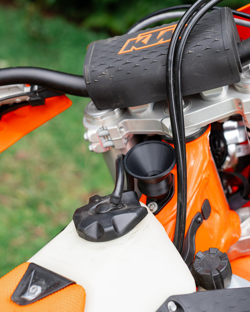 Close-up of a KTM motorcycle 2-stroke oil filler with a DIRT-EH 2-stroke oil funnel
