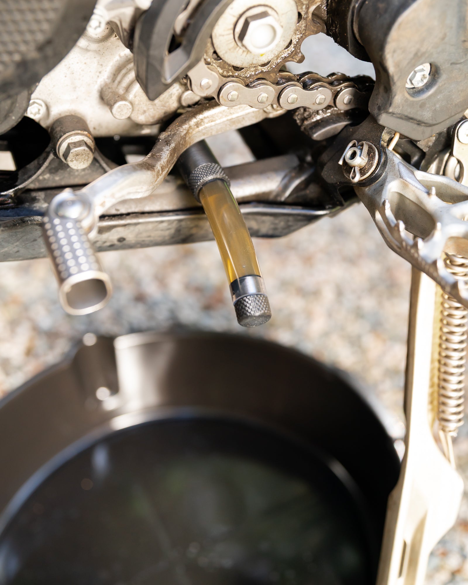Close-up of a KTM motorcycle 2-stroke 4-stroke engine with a DIRT-EH oil drain tool