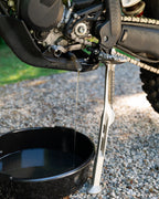 Close-up of a KTM motorcycle 2-stroke 4-stroke engine with a DIRT-EH oil drain tool
