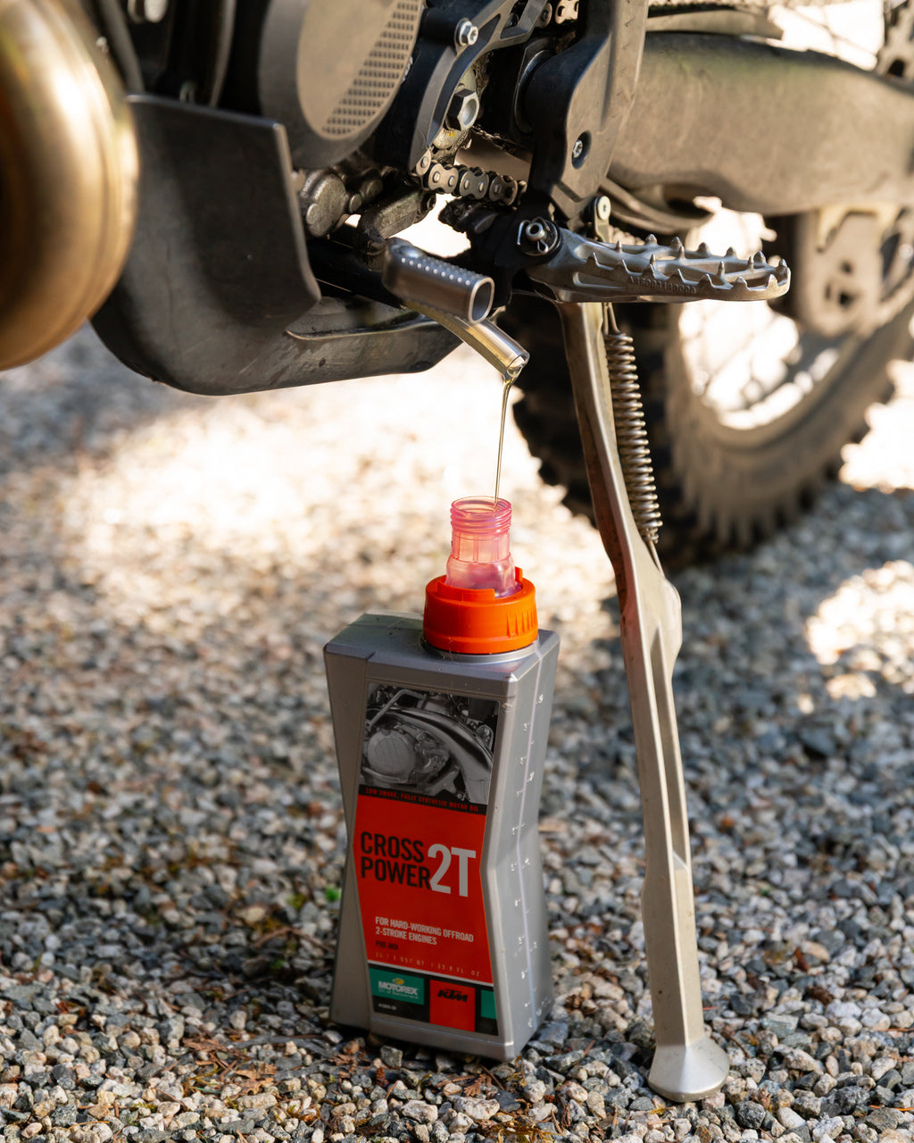 Close-up of a KTM motorcycle 2-stroke 4-stroke engine with a DIRT-EH oil drain tool