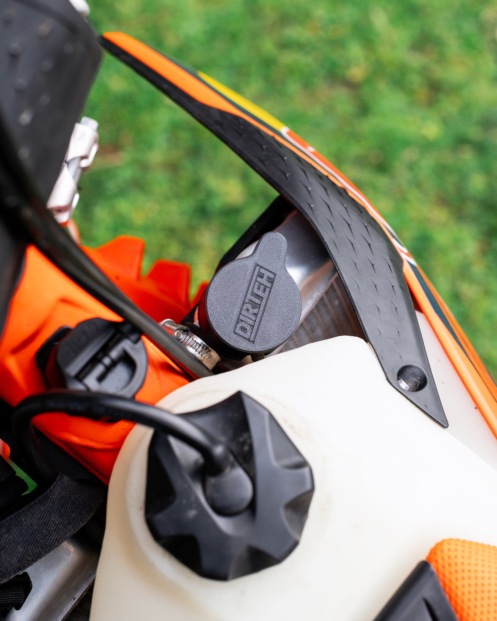 Close-up of a KTM motorcycle radiator with a DIRT-EH radiator cap removal tool