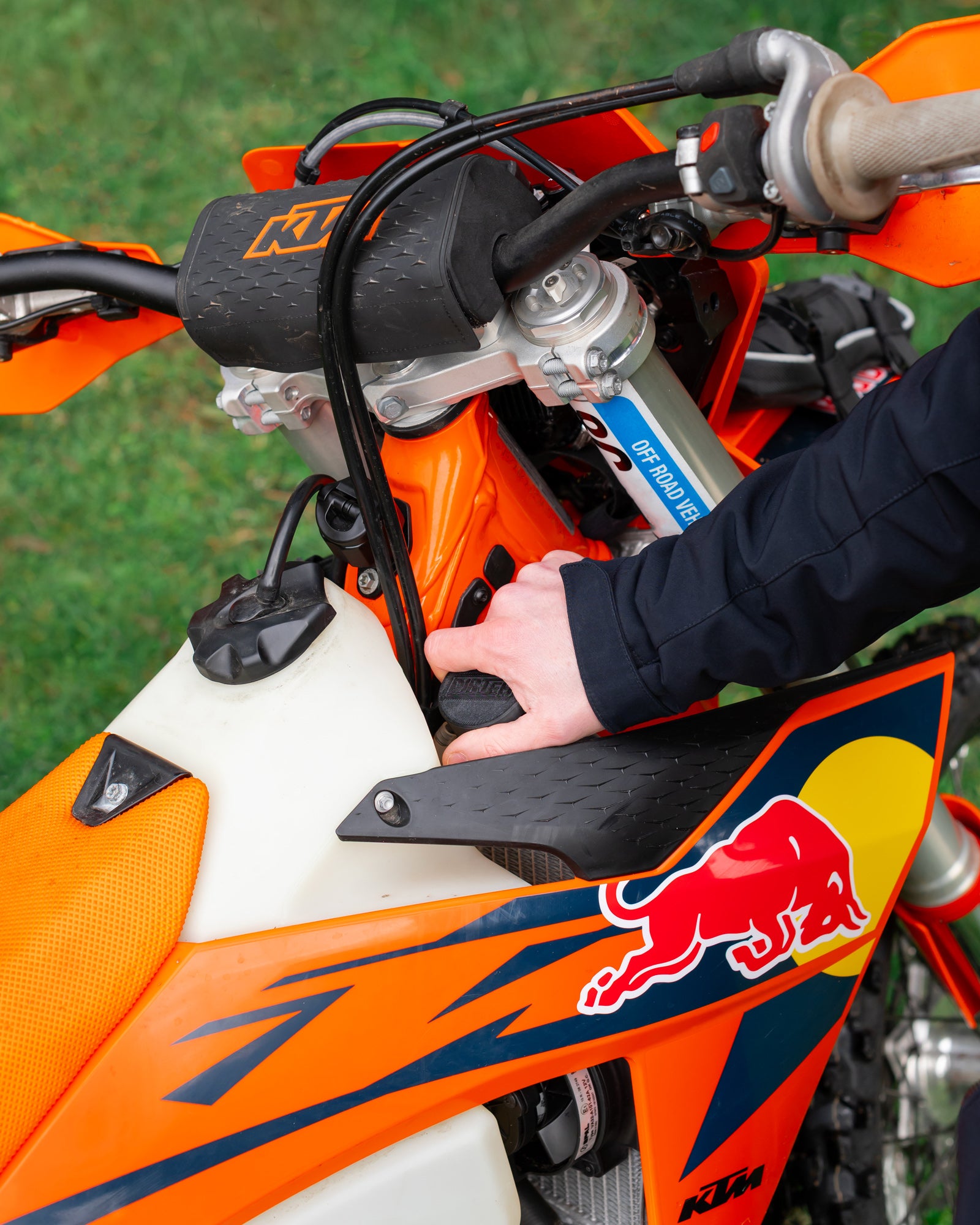 Close-up of a KTM motorcycle radiator with a DIRT-EH radiator cap removal tool