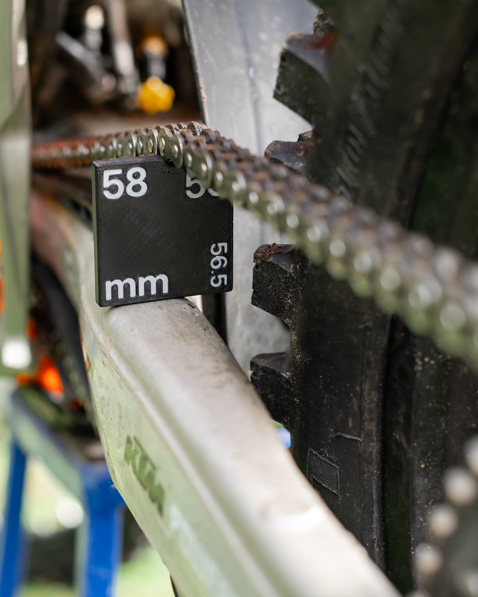 Close-up of a KTM motorcycle chain a DIRT-EH chain slack gauge