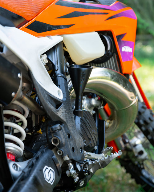 Close-up of a KTM motorcycle engine with a DIRT-EH threaded oil funnel