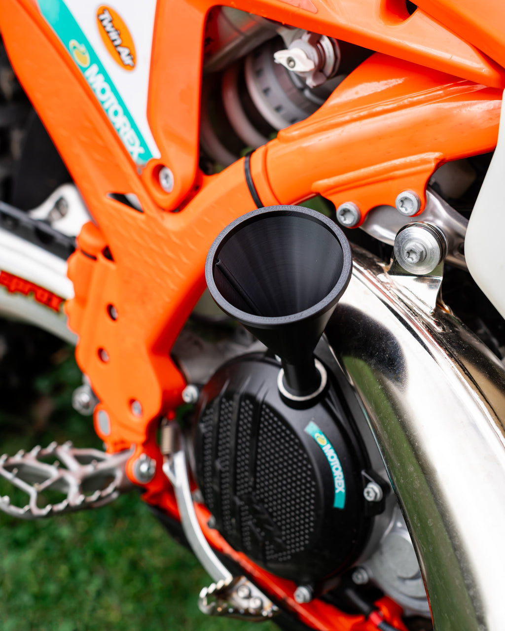 Close-up of a KTM motorcycle engine with a DIRT-EH threaded oil funnel