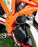 Close-up of a KTM motorcycle engine with a DIRT-EH threaded oil funnel