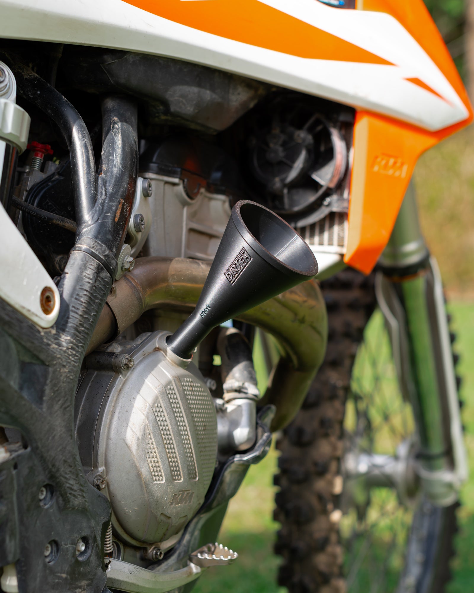 Close-up of a KTM motorcycle engine with a DIRT-EH threaded oil funnel